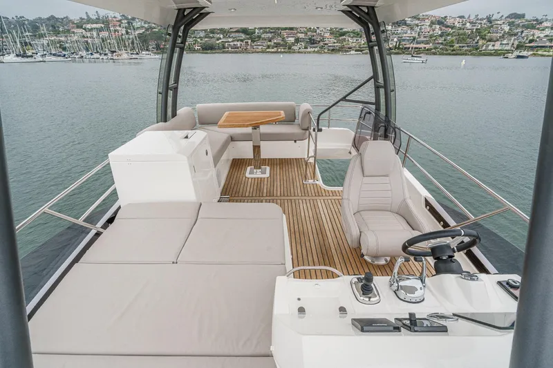 Slide: The Image of 2021 Prestige 420 Fly yacht flybridge with seating, helm, and scenic marina view. - 18