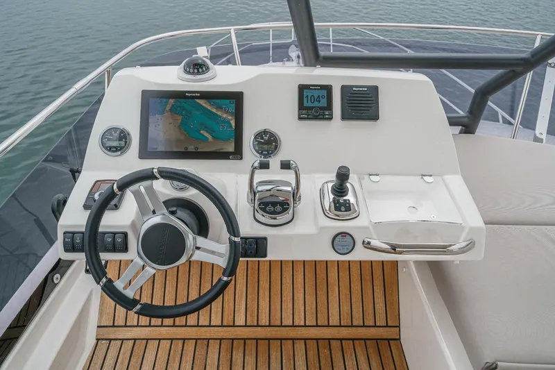 Slide: The Image of Cockpit of 2021 Prestige 420 Fly yacht with modern navigation controls and wooden flooring. - 21