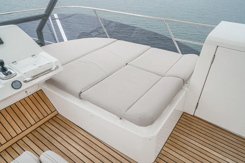 Slide: The Image of 2021 Prestige 420 Fly yacht with cushioned sunbed and teak deck, overlooking the ocean. - 22