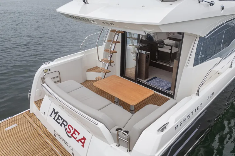 Slide: The Image of Prestige 420 Fly 2021 yacht with outdoor seating and table on calm water. - 29