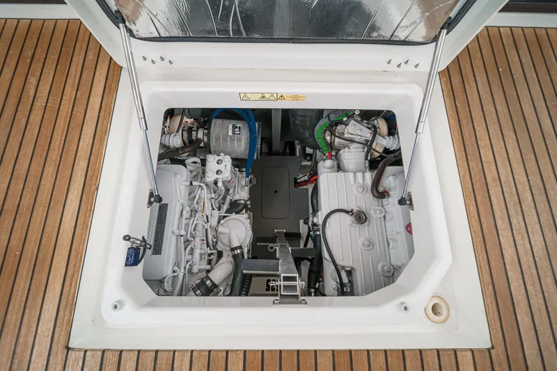 Slide: The Image of Engine compartment of 2021 Prestige 420 Fly yacht, showcasing mechanical components and wooden deck. - 68