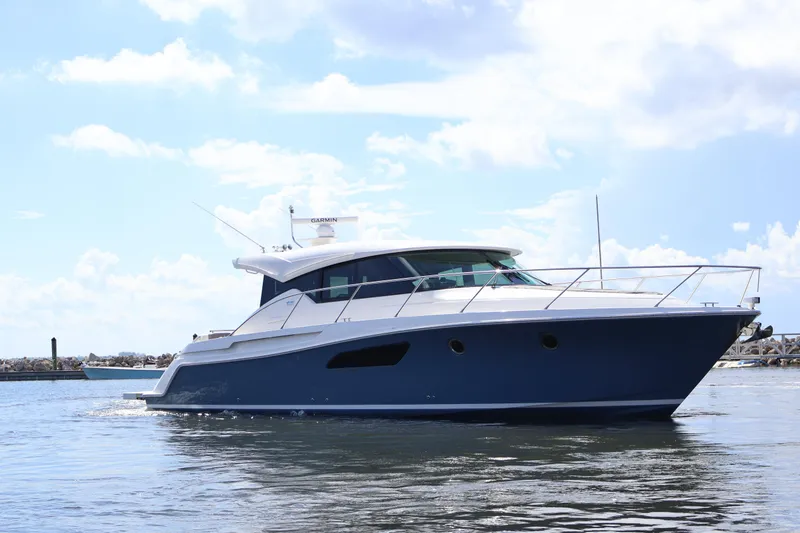 Slide: The Image of 2020 Tiara Yachts C44 Coupe cruising on calm waters under a clear sky. - 10