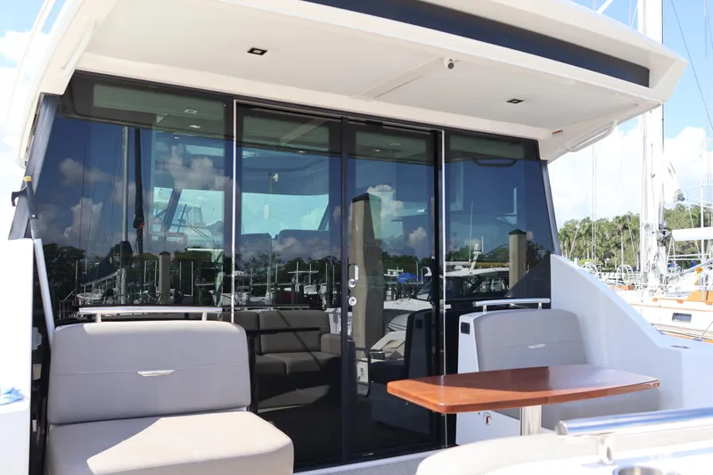 Slide: The Image of 2020 Tiara Yachts C44 Coupe with sleek glass doors and outdoor seating area. - 16