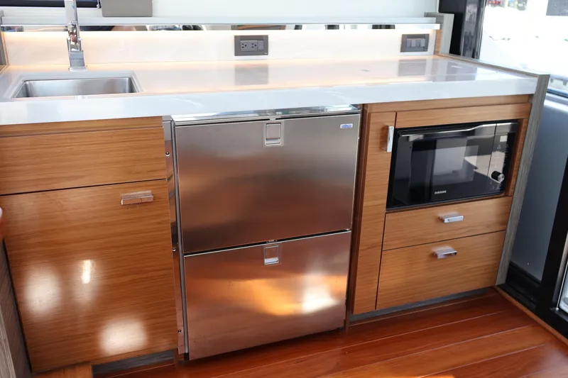 Slide: The Image of Modern kitchen in 2020 Tiara Yachts C44 Coupe with stainless steel appliances and wood cabinetry. - 40