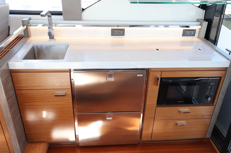 Slide: The Image of Modern kitchen in 2020 Tiara Yachts C44 Coupe with stainless steel appliances and wood cabinetry. - 42