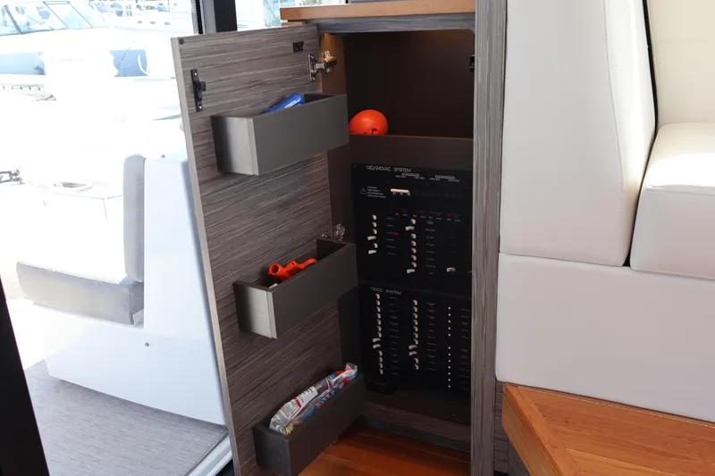 Slide: The Image of 2020 Tiara Yachts C44 Coupe electrical panel with storage compartments and modern design. - 55