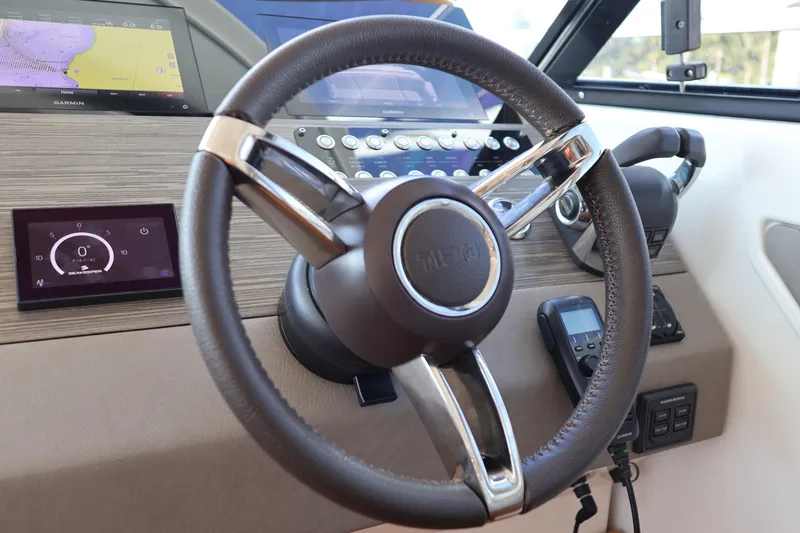 Slide: The Image of Steering wheel and dashboard of 2020 Tiara Yachts C44 Coupe with navigation displays. - 62