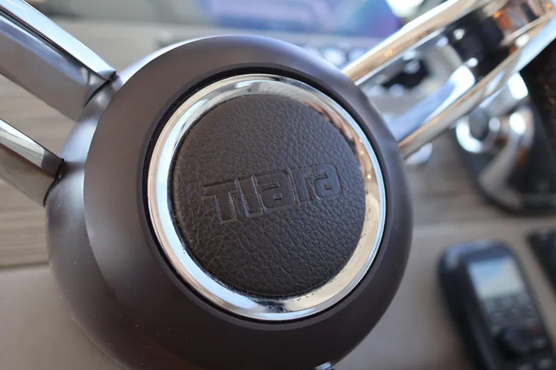 Slide: The Image of Steering wheel of 2020 Tiara Yachts C44 Coupe, featuring leather and chrome details. - 63