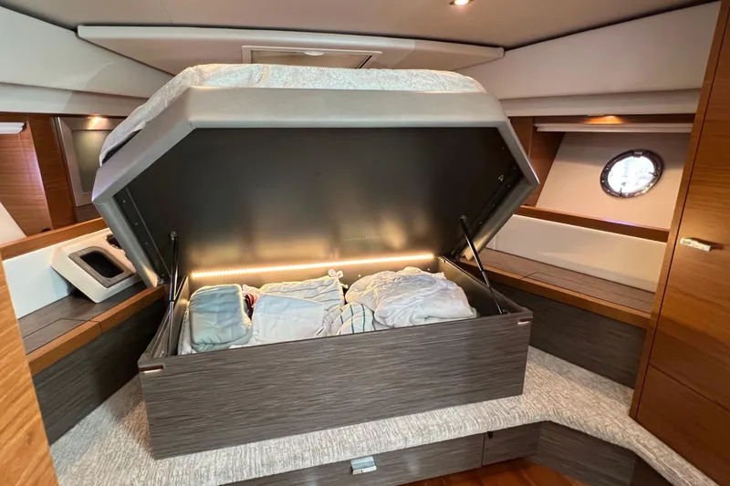 Slide: The Image of 2020 Tiara Yachts C44 Coupe interior with under-bed storage open, showcasing modern design. - 77