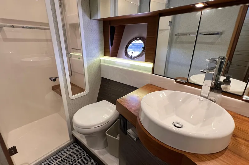 Slide: The Image of Luxurious bathroom in 2020 Tiara Yachts C44 Coupe with modern fixtures and porthole window. - 83
