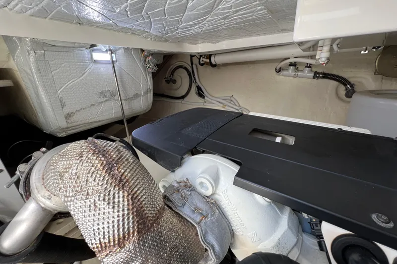Slide: The Image of Engine room of 2020 Tiara Yachts C44 Coupe, showcasing mechanical components and insulation. - 98