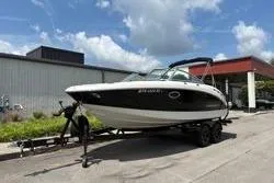 Slide: The Image of 2013 Chaparral Sunesta 224 boat on trailer, parked outdoors under a cloudy sky. - 4