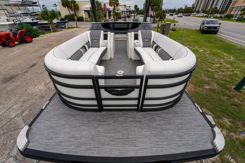 Slide: The Image of 2021 Bennington R25 Sport pontoon boat with luxurious seating, parked near a road. - 11