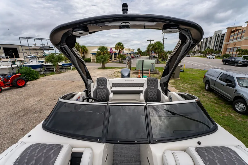 Slide: The Image of 2021 Bennington R25 Sport boat with sleek design and luxurious seating, parked outdoors. - 16