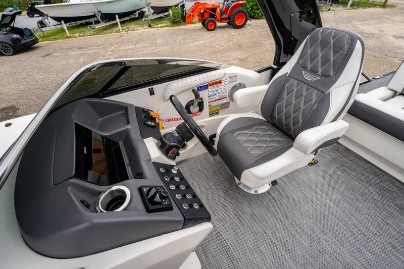 Slide: The Image of Captain's seat and helm of 2021 Bennington R25 Sport boat, featuring modern controls. - 25