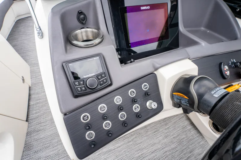Slide: The Image of 2021 Bennington R25 Sport dashboard with controls, cup holder, and Simrad display. - 26