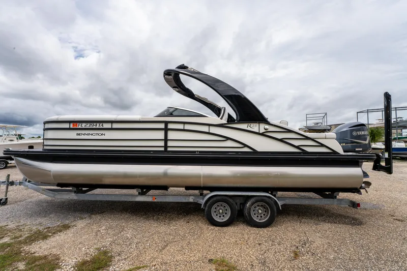 Slide: The Image of 2021 Bennington R25 Sport pontoon boat on trailer under cloudy sky. - 9