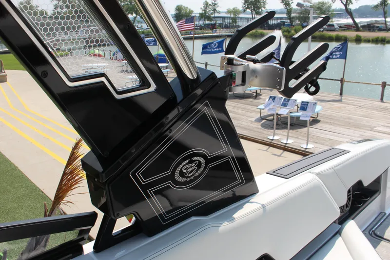 Slide: The Image of 2025 Cobalt R8 Surf boat detail with sleek black and white design at a marina. - 22