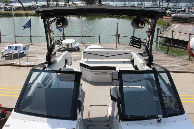 Slide: The Image of 2025 Cobalt R8 Surf boat docked by a serene lake, showcasing sleek design and spacious seating. - 24
