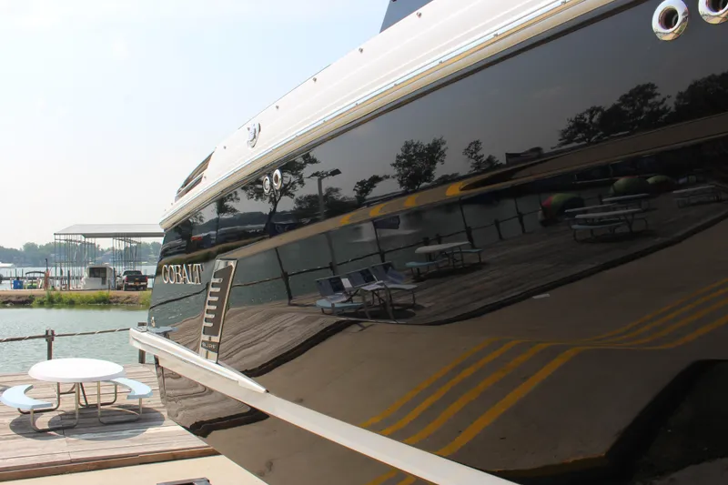 Slide: The Image of 2025 Cobalt R8 Surf boat docked by a serene lakeside. - 3