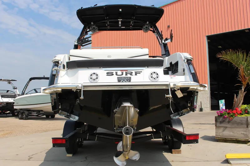 Slide: The Image of 2025 Cobalt R8 Surf boat at a marina, rear view with trailer. - 5