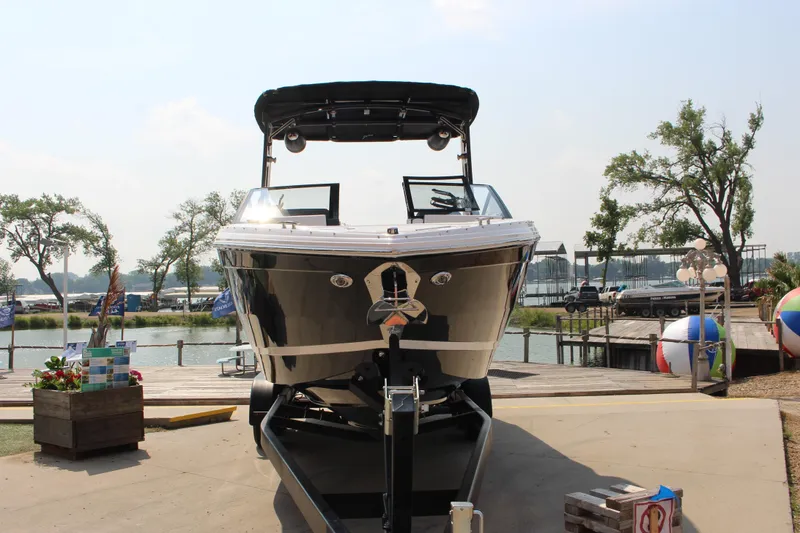 Slide: The Image of 2025 Cobalt R8 Surf boat on trailer by a lakeside dock. - 8