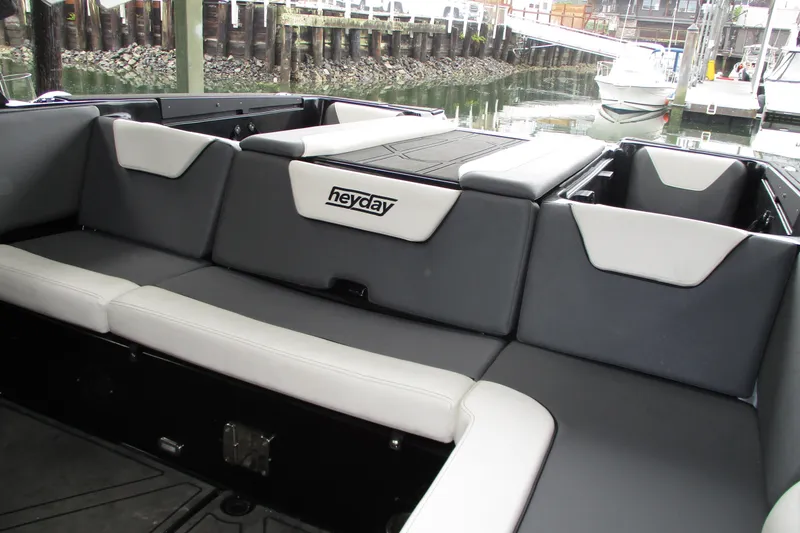 Slide: The Image of 2023 Heyday WT-2DC boat interior with gray and white seating, docked by the water. - 14