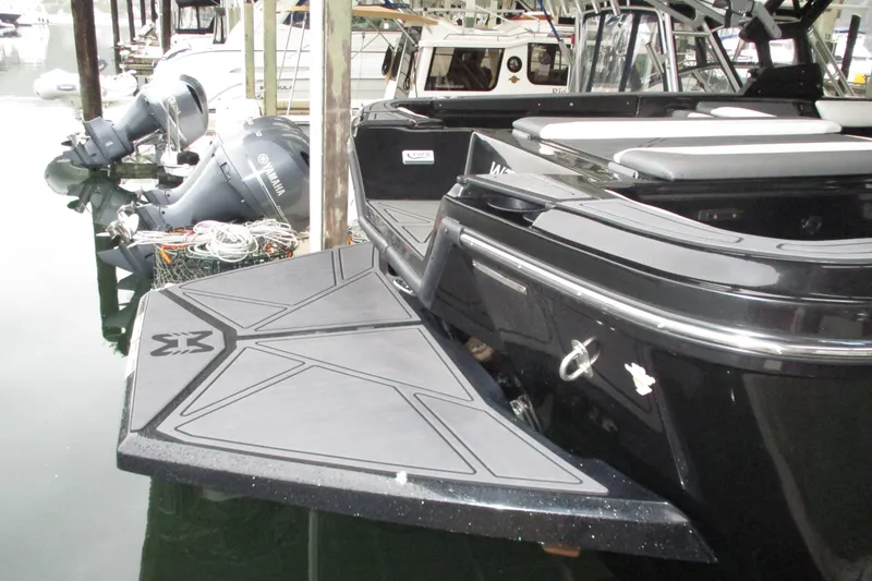 Slide: The Image of 2023 Heyday WT-2DC boat docked, showcasing sleek black design and swim platform. - 17