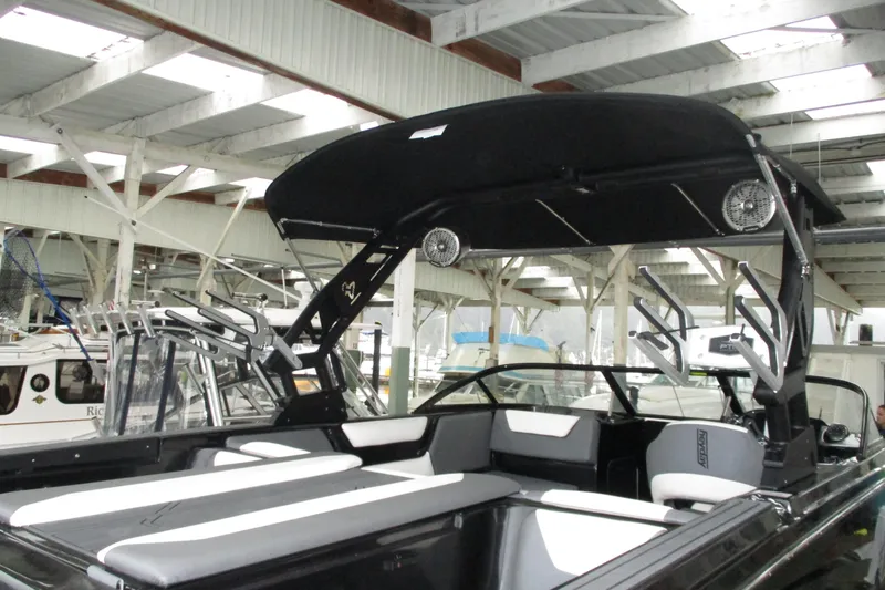 Slide: The Image of 2023 Heyday WT-2DC boat with black canopy and seating, docked in a covered marina. - 19