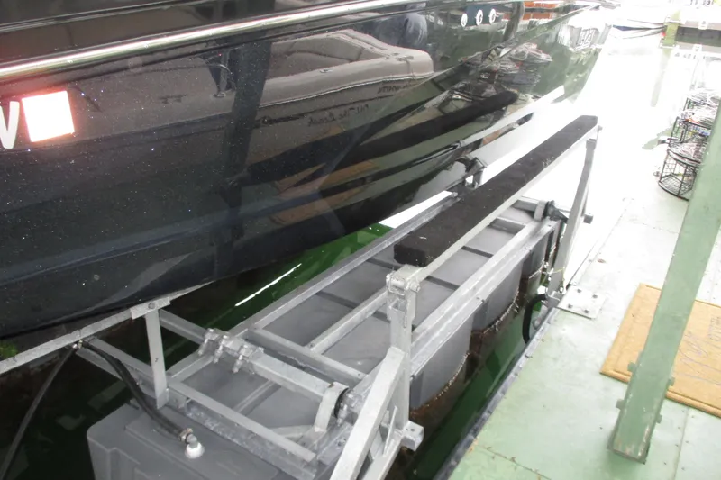 Slide: The Image of 2023 Heyday WT-2DC boat on a lift, showcasing sleek black hull design. - 22