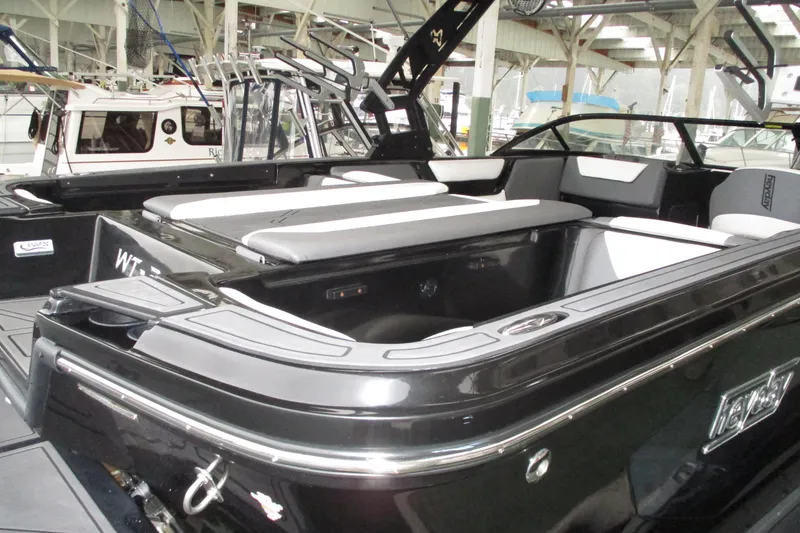 Slide: The Image of 2023 Heyday WT-2DC boat interior with sleek black and white seating in a marina setting. - 18