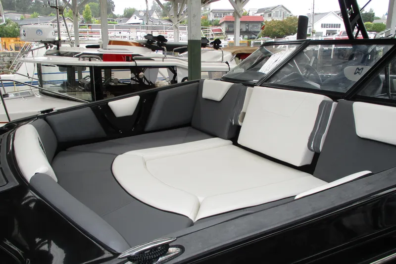 Slide: The Image of 2023 Heyday WT-2DC boat interior with sleek black and white seating at a marina. - 4