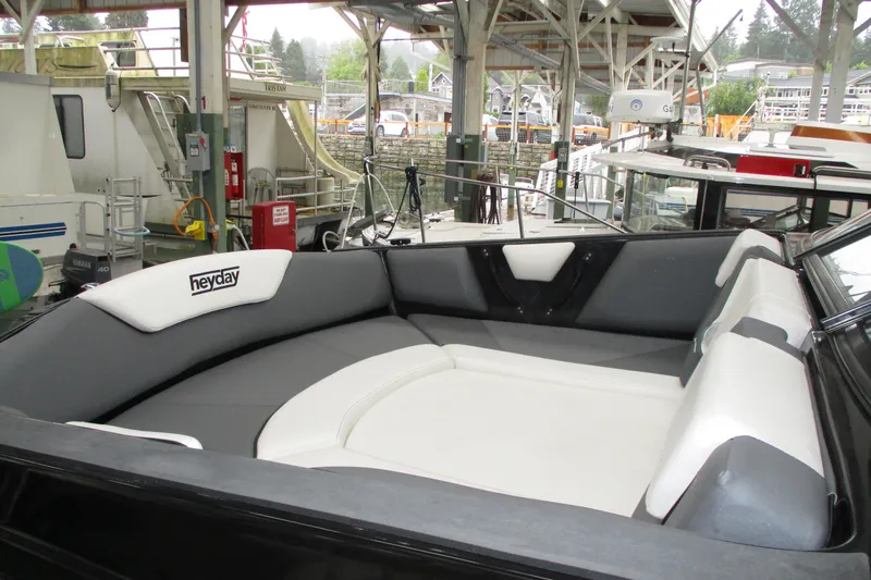 Slide: The Image of 2023 Heyday WT-2DC boat interior with gray and white seating in a marina setting. - 5