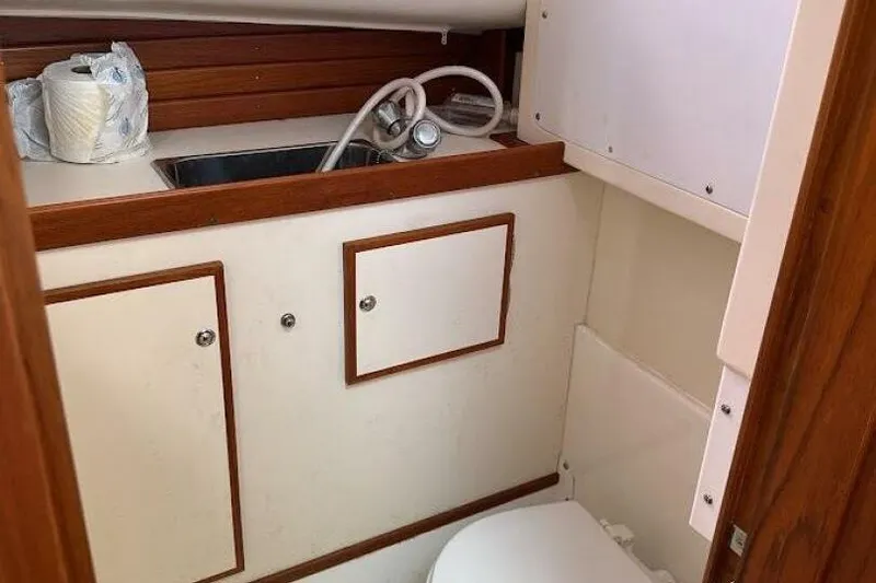 Slide: The Image of Compact bathroom in a 2008 Dyer 29 boat, featuring a sink and storage cabinets. - 5