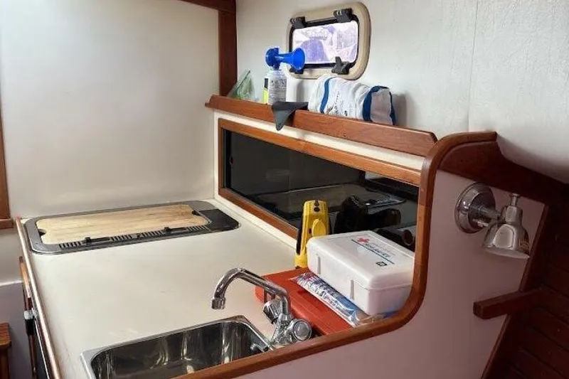 Slide: The Image of Compact kitchen area in a 2008 Dyer 29 boat, featuring a sink and storage. - 6