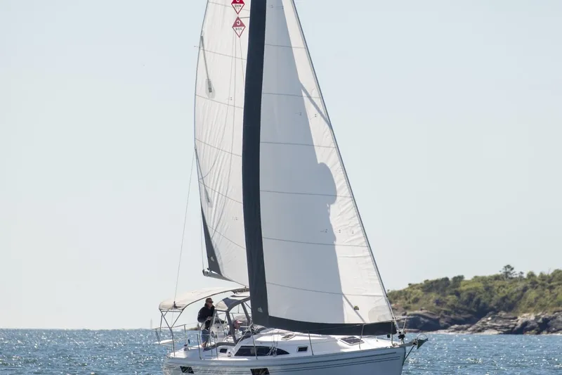 Slide: The Image of Sailboat Catalina 316 (2026) cruising on open water near a rocky shoreline. - 5