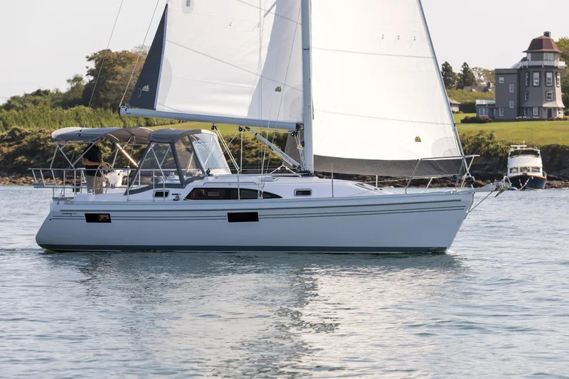 Slide: The Image of 2026 Catalina 316 sailboat cruising on calm waters near a coastal house. - 9