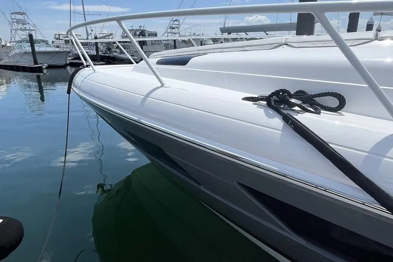 Slide: The Image of 2023 Intrepid 477 Evolution yacht docked in a marina, reflecting on calm water. - 10