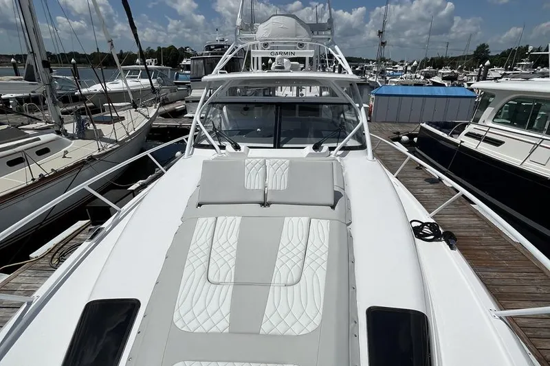 Slide: The Image of 2023 Intrepid 477 Evolution yacht docked, featuring sleek design and luxurious seating. - 12