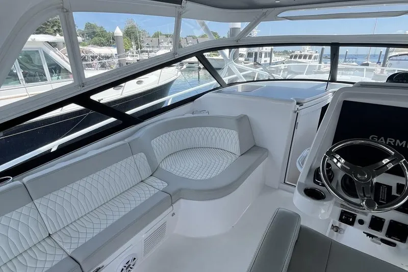 Slide: The Image of 2023 Intrepid 477 Evolution yacht interior with plush seating and modern helm. - 26