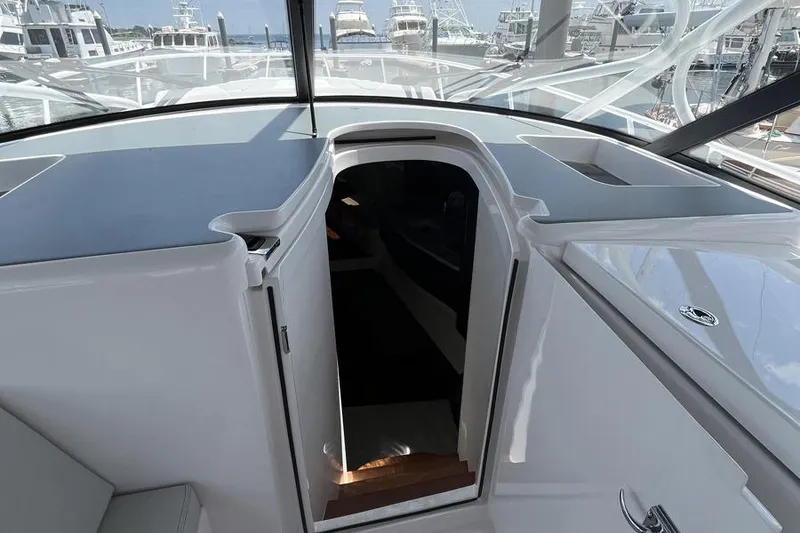 Slide: The Image of 2023 Intrepid 477 Evolution yacht interior entrance with sleek design and marina view. - 36