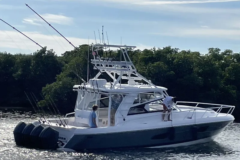 Slide: The Image of 2023 Intrepid 477 Evolution boat on water with fishing rods and two people onboard. - 4