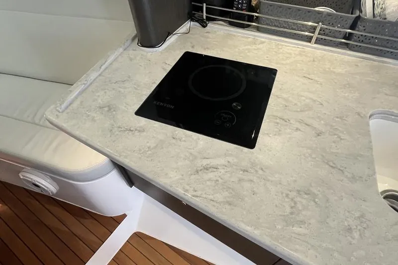 Slide: The Image of 2023 Intrepid 477 Evolution yacht kitchen with sleek countertop and modern cooktop. - 46