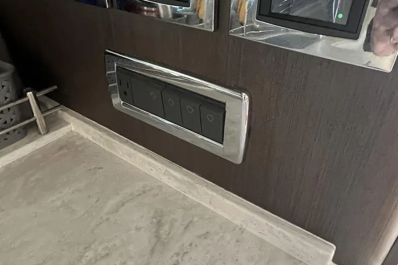 Slide: The Image of Control panel on 2023 Intrepid 477 Evolution yacht, featuring sleek design and modern switches. - 49