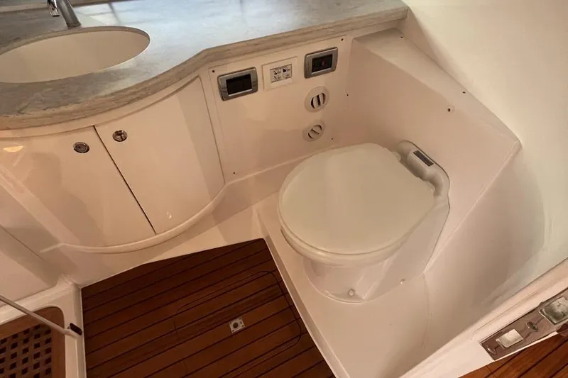 Slide: The Image of 2023 Intrepid 477 Evolution yacht bathroom with modern fixtures and wooden flooring. - 55