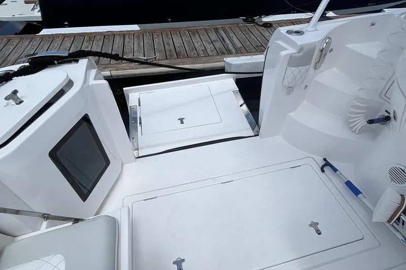 Slide: The Image of 2023 Intrepid 477 Evolution boat deck with storage compartments and dock view. - 60