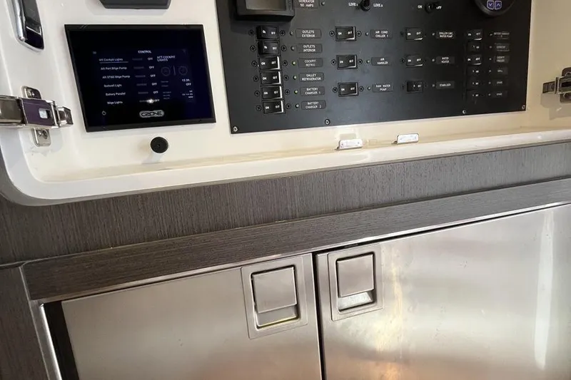 Slide: The Image of Control panel and storage on 2023 Intrepid 477 Evolution boat interior. - 61