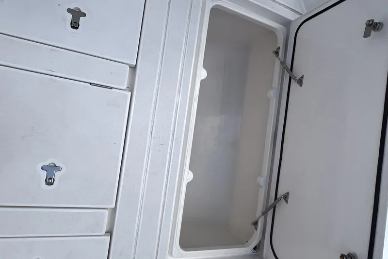 Slide: The Image of Open storage compartment on 2023 Intrepid 477 Evolution boat, showcasing interior space and secure latches. - 66