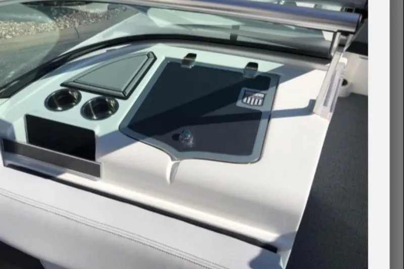 Slide: The Image of 2019 MasterCraft XT25 boat dashboard with cup holders and storage compartment. - 12
