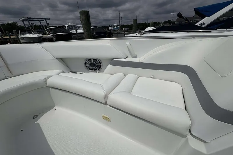 Slide: The Image of 2004 Formula 2800 BR boat interior with white seating and speaker, docked at marina. - 13
